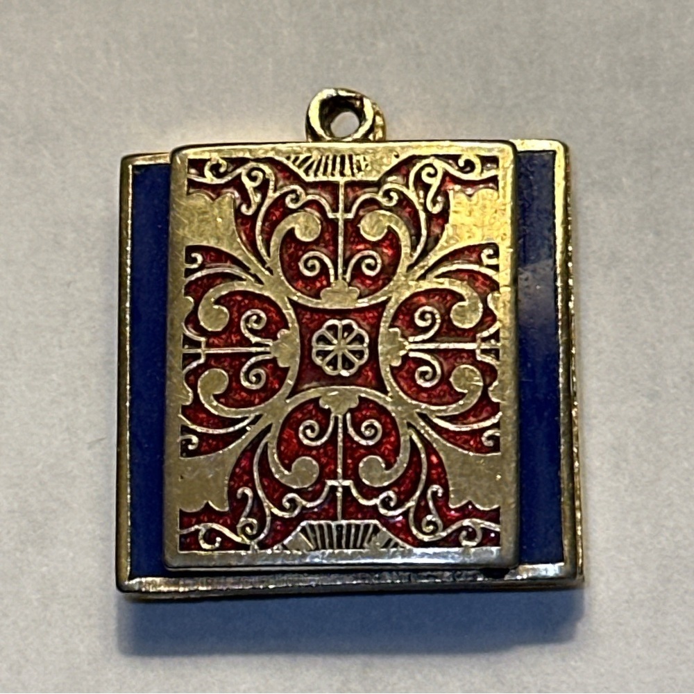 Unbranded pendant - gold scroll design with red behind and blue background